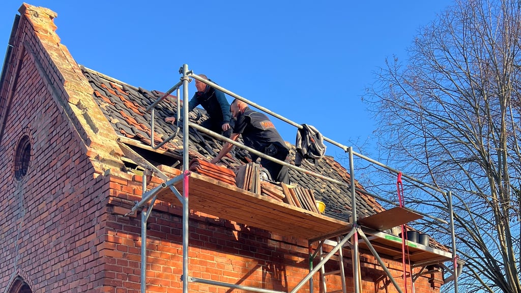 Mitarbeiter der Dingelstedter Dachdeckerfirma Flick bei der Sanierung des Daches der Friedhofskapelle Dingelstedts (Landkreis Harz). 