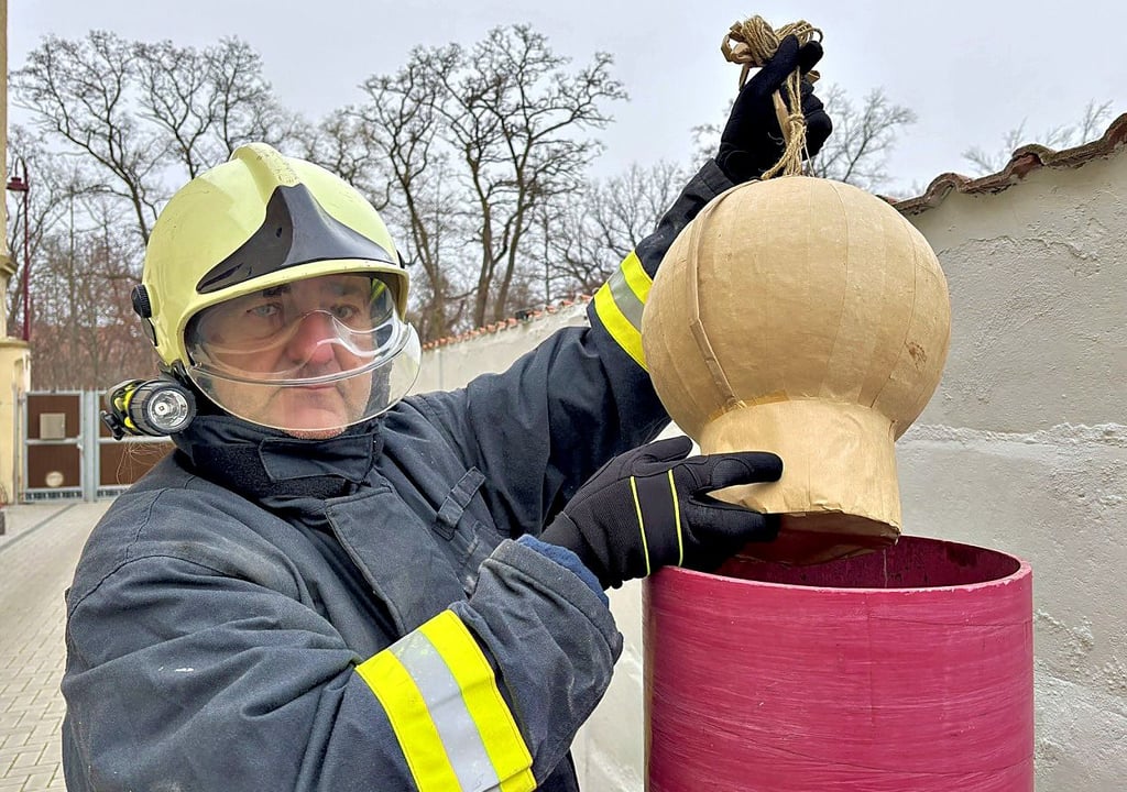 Uwe Stößel demonstriert, wie man eine Feuerwerksbombe der Kategorie 4 mit Zündschnur im Mörser versenkt, aus dem sie gestartet wird.