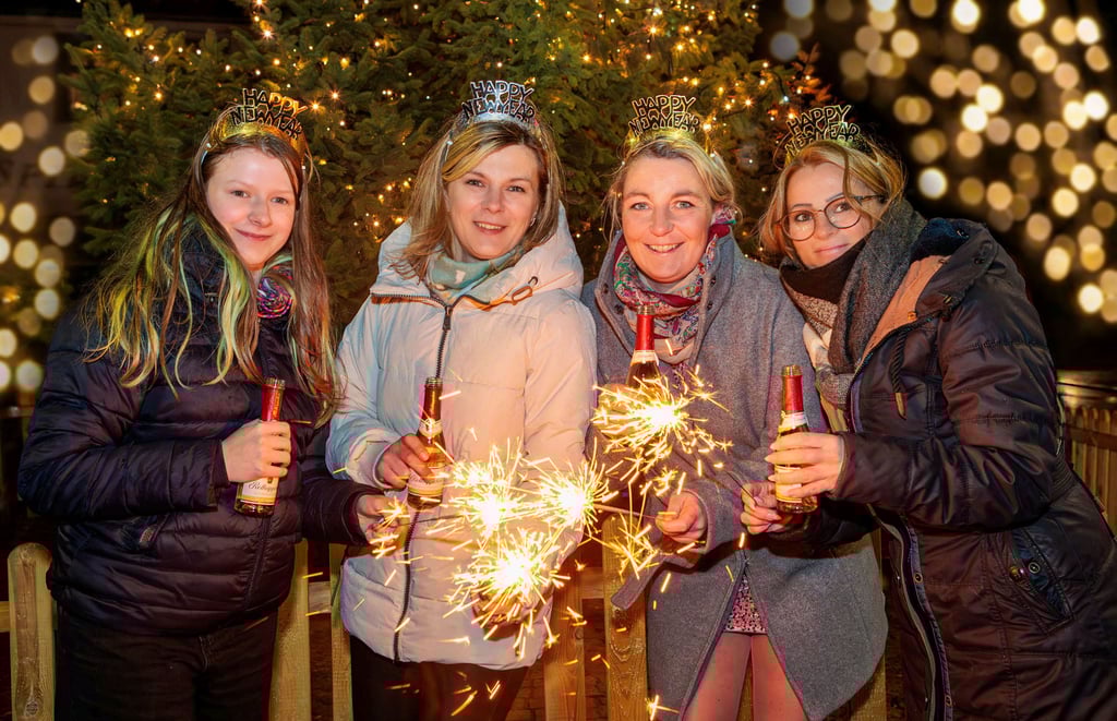 Finja (von links), Ricarda, Anja und    Christiane stoßen auf dem Zeitzer Rossmarkt das neue Jahr an und lassen Wunderkerzen strahlen. 