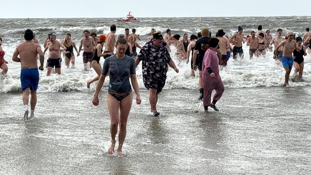 Bei Schneeregen stiegen Hunderte Schwimmer auf Norderney ins Wasser.