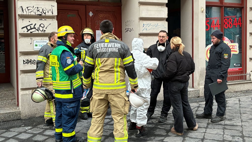 Vertreter der Feuerwehr Magdeburg, des THW und der Polizei beraten vor dem Brandhaus in der Sternstraße in Magdeburg. Statiker nahmen das Wohn- und Geschäftshaus am Freitag (2. Januar 2026) unter die Lupe.