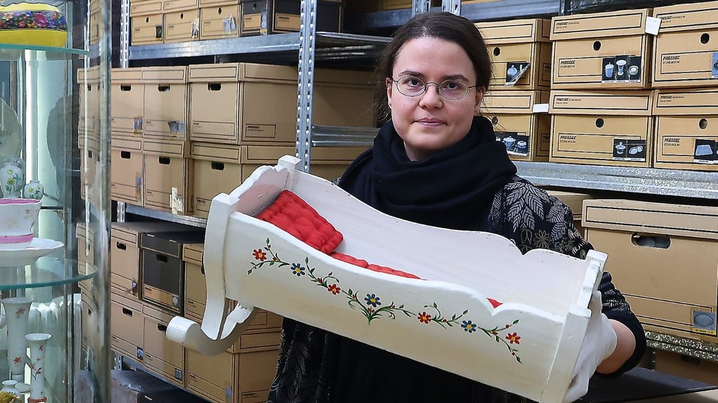 Diese nostalgische Puppenwiege in den Händen von Saskia Knyrim, Dokumentarin im Stadtmuseum Halle, stammt aus den Anfängen des 20. Jahrhunderts und wurde von einer älteren Hallenserin zusammen mit weiterem Spielzeug an das Museum übergeben.