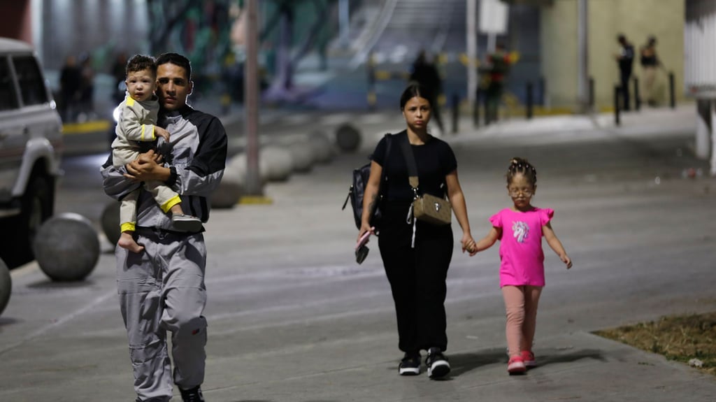 Menschen gehen am Präsidentenpalast Miraflores vorbei, nachdem in Caracas, Venezuela, am Samstag, 3. Januar 2026, Explosionen und tieffliegende Flugzeuge zu hören waren.