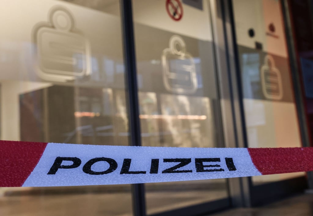 Ein Absperrband der Polizei hängt vor der Filiale der Sparkasse, deren Schließfächer ausgeräumt wurden