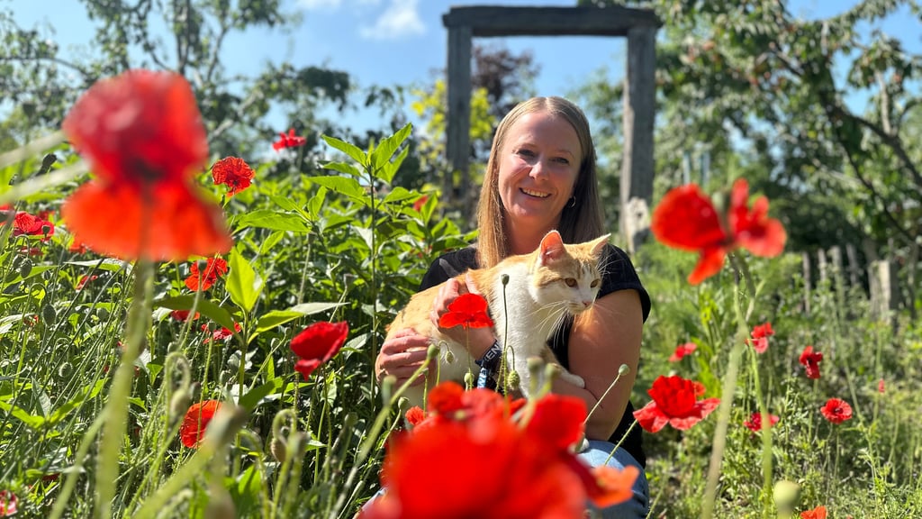 Stephanie Poppeck mit ihrer Katze im heimischen Kräutergarten in Biederitz.