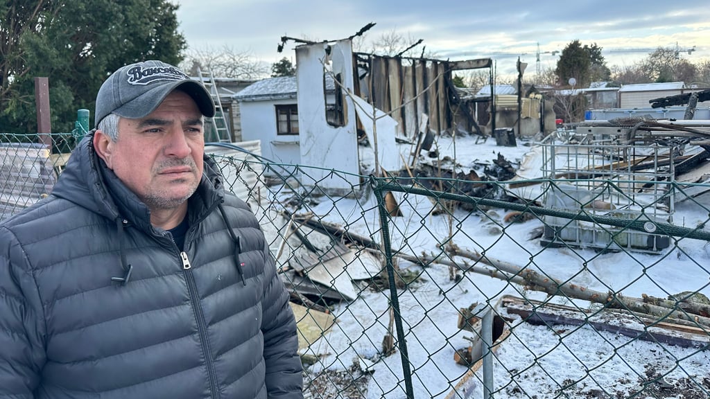 Müslüm Kar steht vor den Resten seiner verbrannten Laube.