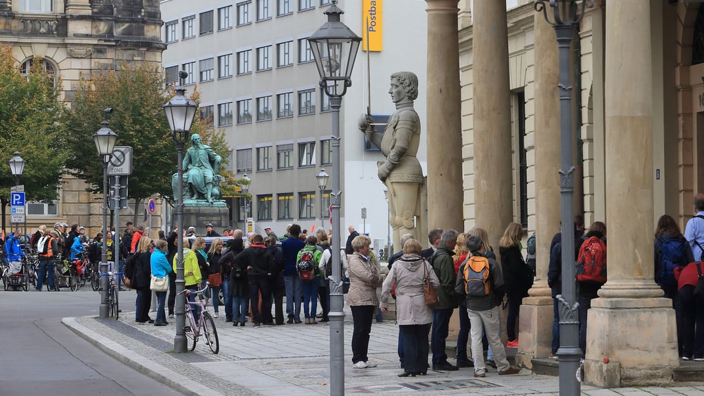 Touristen stehen vor dem Magdeburger Rathaus, dem Roland und dem Otto-von-Guericke-Brunnen. 