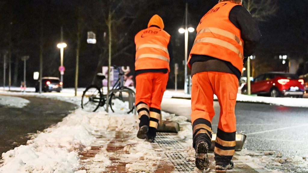 Arbeiter räumen den Schnee mit Schaufeln weg.