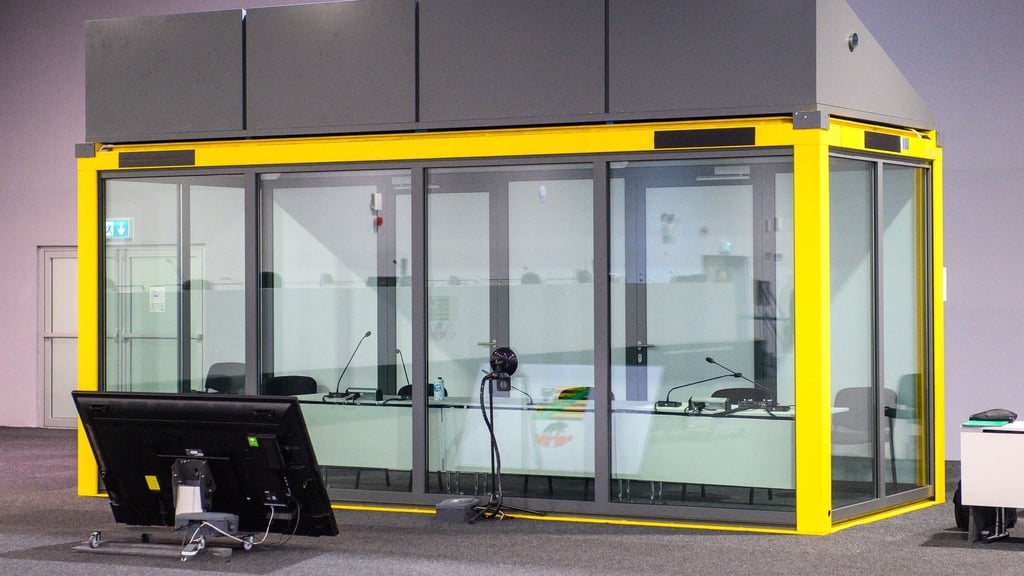 Blick auf den leeren Glaskasten im Gerichtssaal des temporären Gerichtsgebäudes vom Landgericht Magdeburg, in dem normalerweise der Todesfahrer vom Magdeburger Weihnachtsmarkt sitzt. (Archivbild)