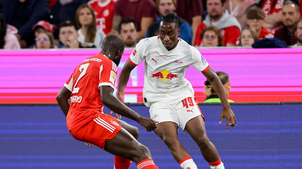 Yan Diomande geht beim Spiel gegen den FC Bayern gegen Dayot Upamecano ins Dribbling.