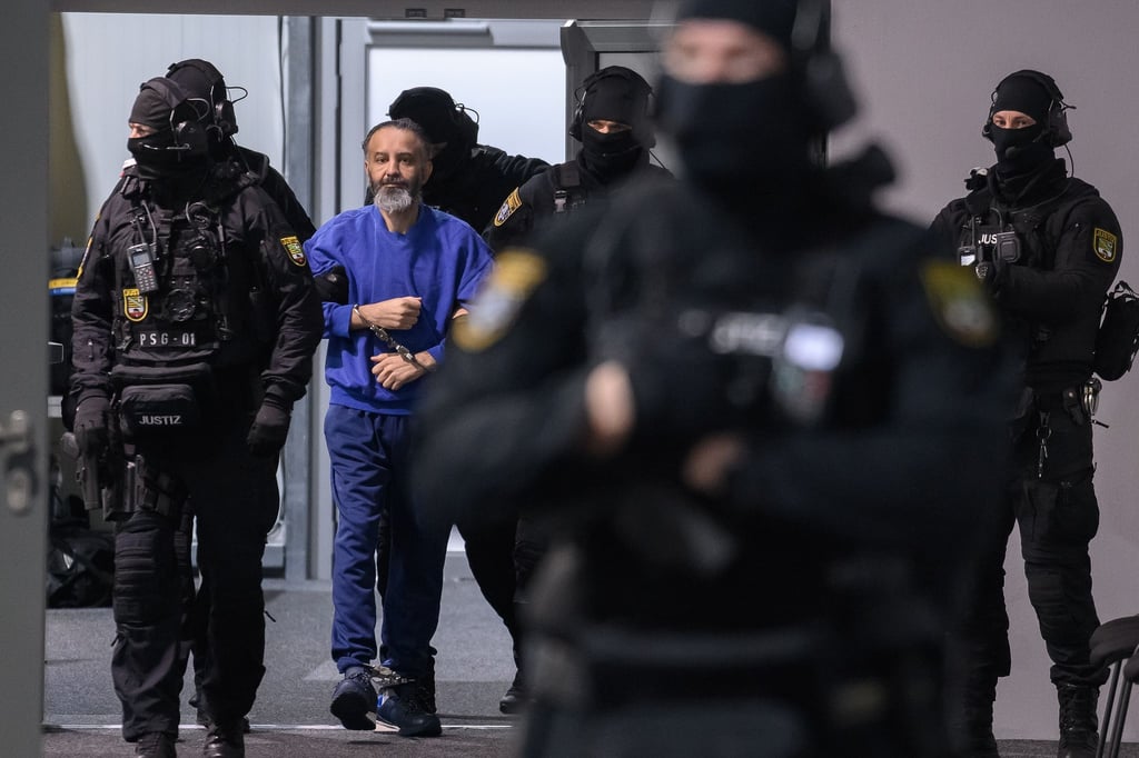 Justizbeamte führen den Angeklagten Taleb al-Abdulmohsen in den Gerichtssaal des temporären Gerichtsgebäudes vom Landgericht Magdeburg.