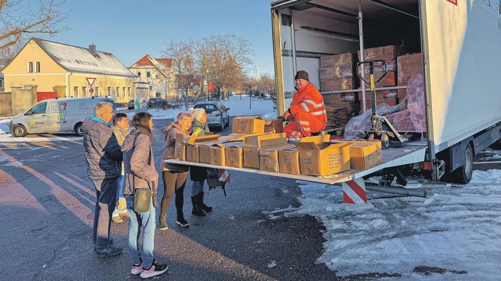 Mitarbeiter von Remondis verteilen in Wolfen auf dem Parkplatz in der Leipziger Straße Gelbe Säcke für die Entsorgung von Leichtverpackungen. 