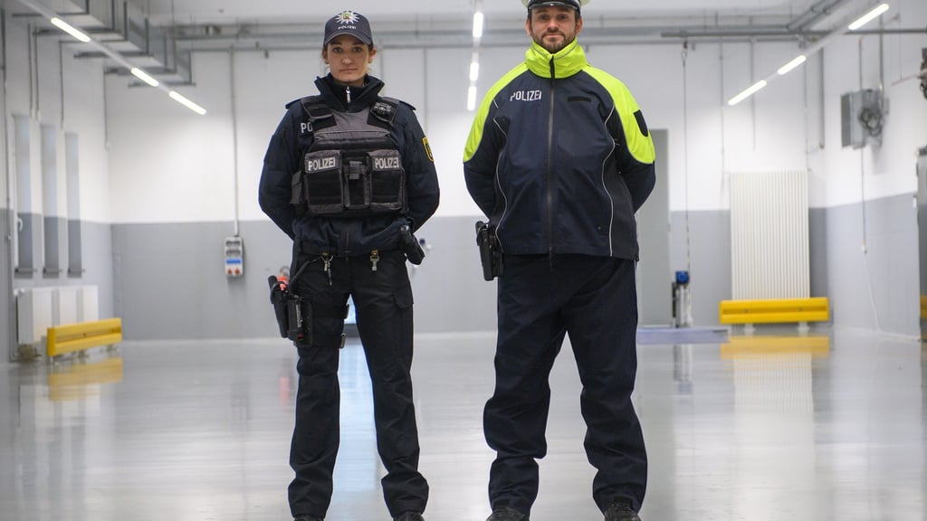 Eine Polizistin und ein Polizist tragen im Lager der Polizeiinspektion Zentrale Dienste der Bereitschaftspolizei die neue Streifendienstbekleidung für die Landespolizei Sachsen-Anhalt.