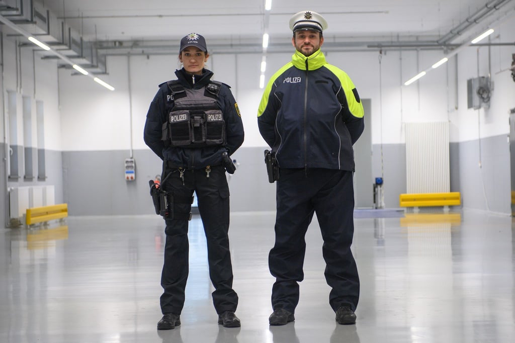 Eine Polizistin und ein Polizist tragen im Lager der Polizeiinspektion Zentrale Dienste der Bereitschaftspolizei die neue Streifendienstbekleidung für die Landespolizei Sachsen-Anhalt.