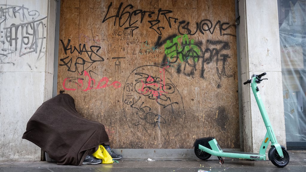 Ein obdachloser Mann hat sich an einem Haus zum Schlafen hingelegt. In Halle sollen für Bedürftige Kälterucksäcke gepackt werden (Symbolbild).
