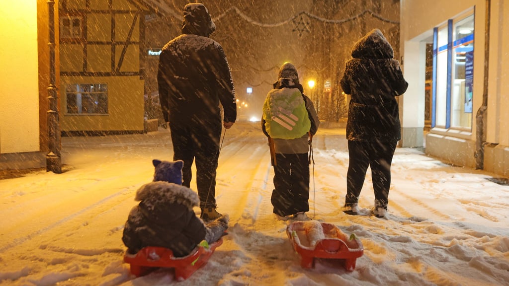 Eltern bringen am Freitagmorgen, 9. Januar, ihre Kinder in Wernigerode mit Schlitten in die Schule.
