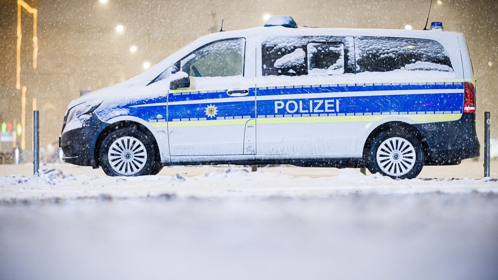 Die glatten Straßen beschäftigen die Polizei. In Hannover steht ein Einsatzwagen im Schneefall nahe des Hauptbahnhofs.