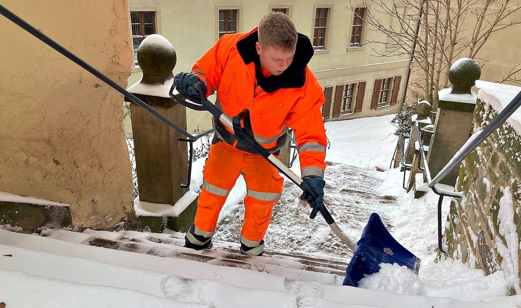 Jesse Steinhausen schiebt den Schnee auf der Schenktreppe zur Seite. 