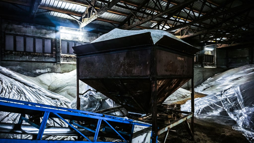 Über ein Fließband gelangt das Salz in den Salztreuer des Traktors.