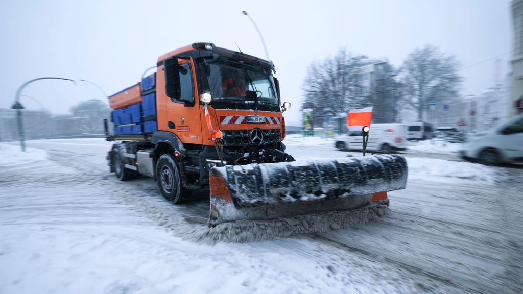 Winter-Wetter: Ein Räum-und Streufahrzeug schiebt Schnee von einer Straße.