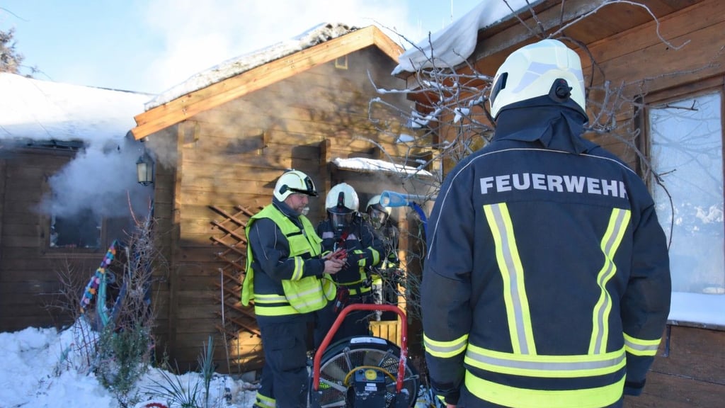 Der Einsatzleiter übergibt beim Brandeinsatz in der Gartensparte an der Gänsebreite in Haldensleben den Atemschutzgeräteträgern die Wärmebildkamera, um damit versteckte Glutnester im Gartenhäuschen zu finden.