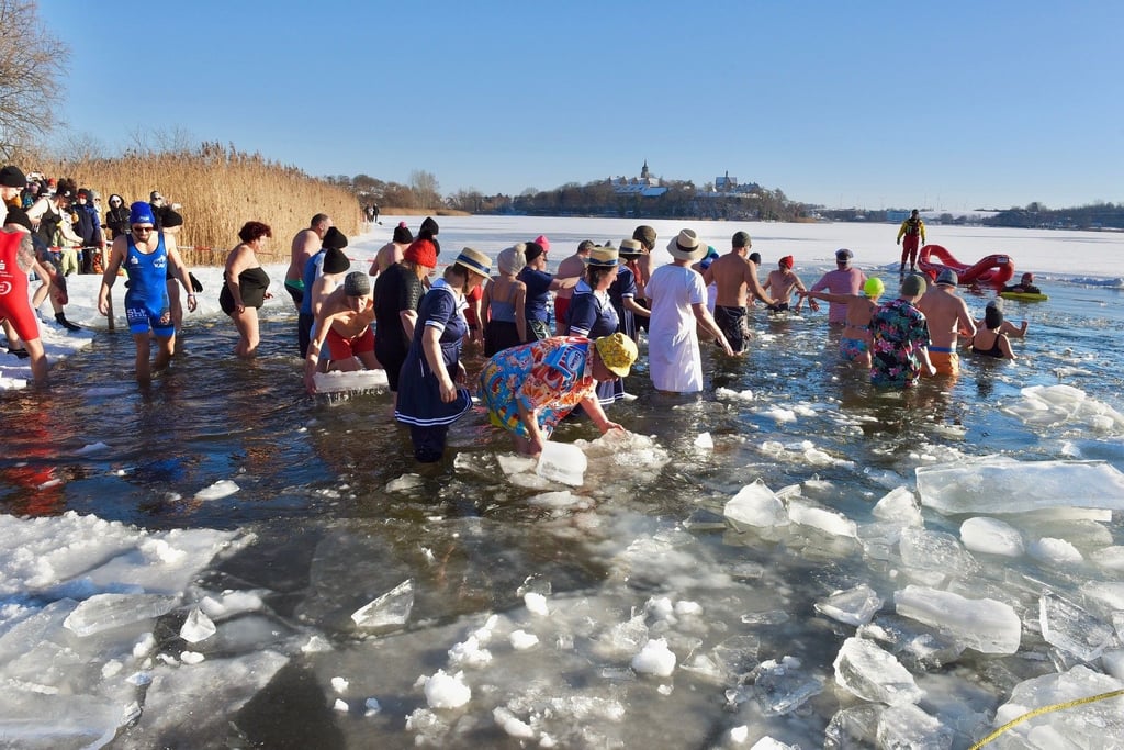 Mit Mütze und Kostüm: Beim Naujahrsschwimmen am Süßen See sind am Sonntag rund 50 Teilnehmer in das eisige Wasser gestiegen.