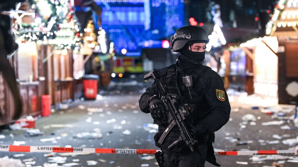 Ein Polizist nach der Amokfahrt auf dem Magdeburger Weihnachtsmarkt in der Mittelgasse des Marktes. Hier wurden viele Opfer vom Tatfahrzeug erfasst.