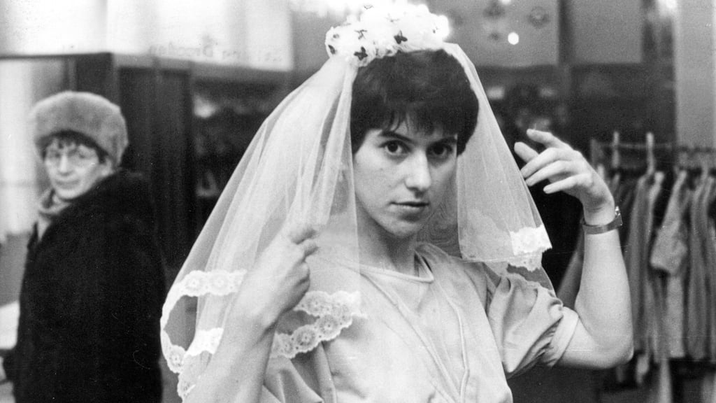 Eine Verkäuferin präsentiert einen Brautschleier aus Dederon-Batist.