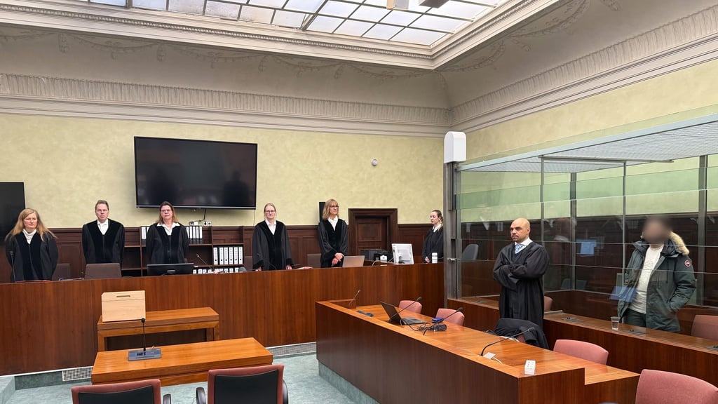 Der Angeklagte, ein mutmaßliches Mitglied der Hisbollah, steht bei seinem Prozess im Gerichtssaal (r.)