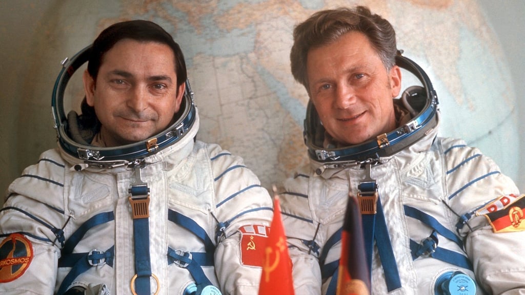 Valeri Bykowski (links) aus der Sowjetunion und der DDR-Kosmonaut Sigmund Jähn posieren im August 1978 in ihren Raumanzügen vor einem Globus.