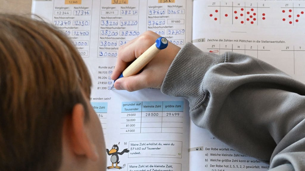 Ein Viertklässler arbeitet in seinem Matheheft. (Symbolbild)