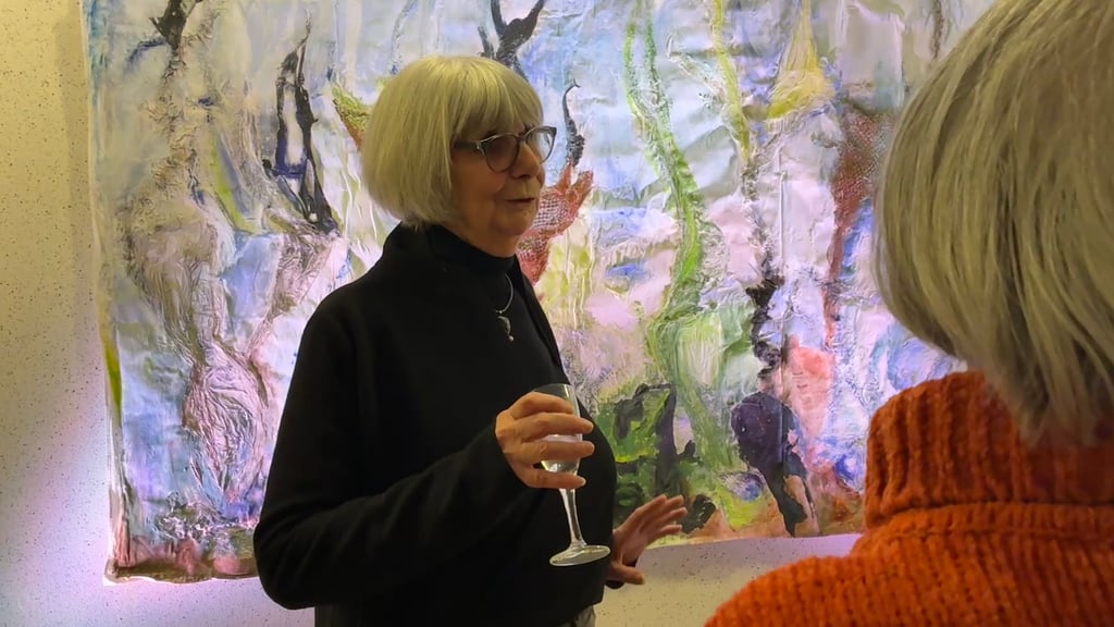 Kursleiterin Jutta Schulz präsentiert eines der Gemeinschaftsprojekte des Kunstkurses zur Ausstellungseröffnung in der Musik- und Kunstschule Stendal vor.