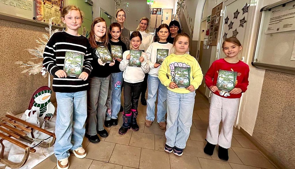 Franziska Buse und Kerstin Staab (hinten v.l.)    überreichen 111 Kinderbücher an Schüler der Grundschule Zahna.