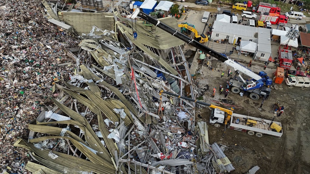 Die Einsatzkräfte suchen unter anderem mit einem Kran in den Abfall-Massen.