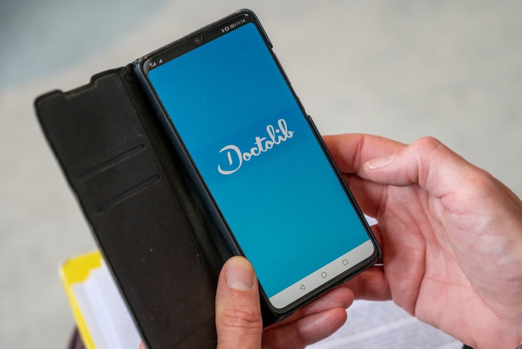Ein Mann öffnet auf einem Smartphone die Doctolib-App. (Symbolbild)