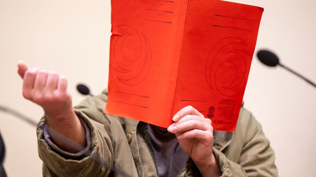 Der Angeklagte verdeckte sein Gesicht zum Prozessauftakt zunächst mit einer Mappe.