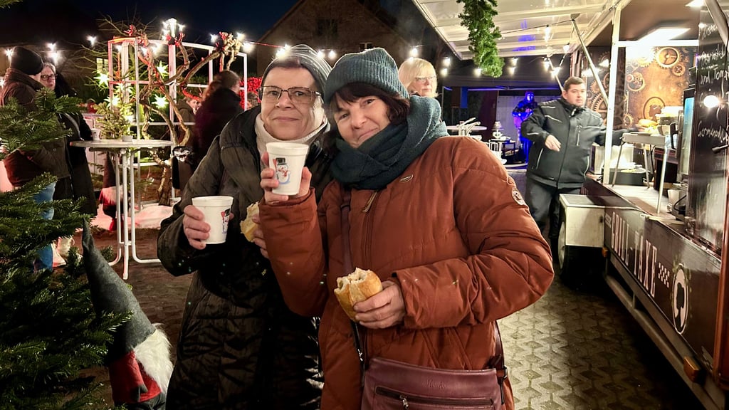 Die Freundinnen Katrin Krumscheid (r.) und Manuela Heider sind das erste Mal auf dem kleinen Wintermarkt am Jungfernstieg und genießen den Abend mit Punsch.
