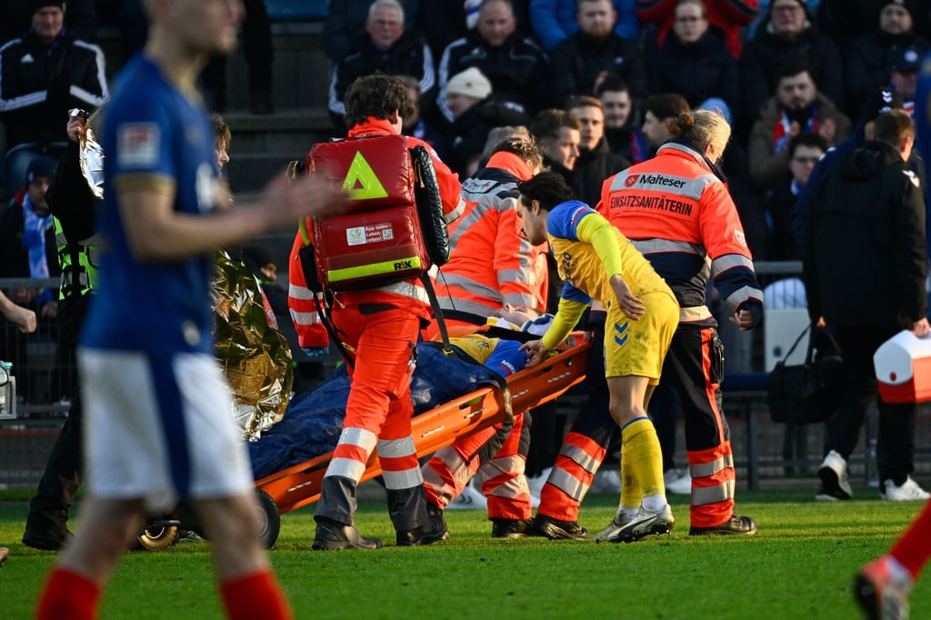 Paderborns Spieler Calvin Brackelmann wird nach einer Verletzung von Sanitätern auf einer Trage vom Spielfeld gebracht.