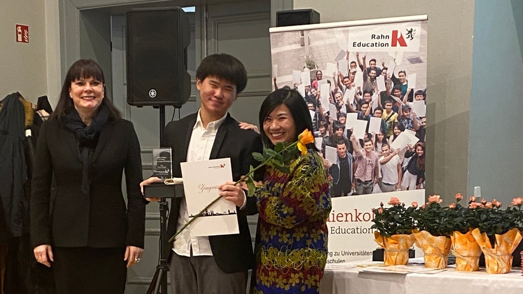 Bestnoten-Schüler Devon Aurelius erhält sein Zeugnis von Grit Zorn (Prokuristin der Rahn Education, links) und Hanh Nguyen (Leiterin des Studienkollegs).