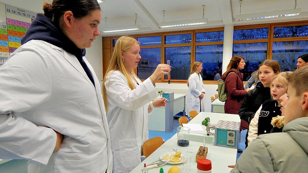 Alina (r.) und Melissa sind im Leistungskurs Chemie und führen gemeinsam mit den Besuchern Experimente durch.