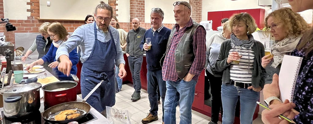 Kochworkshop mit Rudolf Sasse (am Herd) in den Hauswirtschaftsräumen der Gemeinschaftschule in Tangerhütte. Es wurden außergewöhnliche Teile vom Tier in verschiedenen Varianten verwendet, um wirklich alles verwerten zu können, was beim Schlachten anfällt.