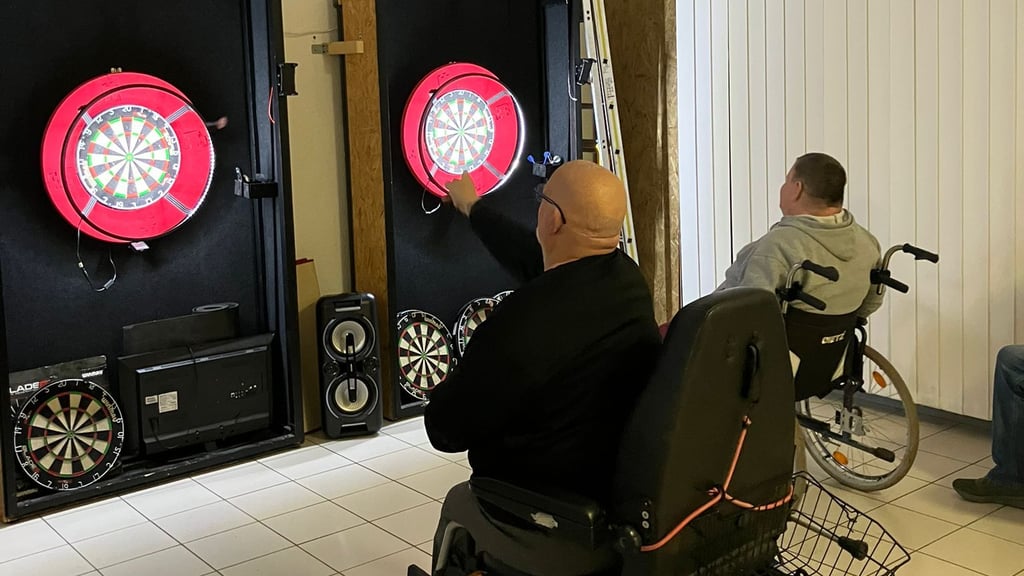 Die Fangruppe der Rollstuhlfahrer vom HFC spielt bei den „Dart Maulis Halle“ an selbstgebauten, höhenverstellbaren Anlagen.