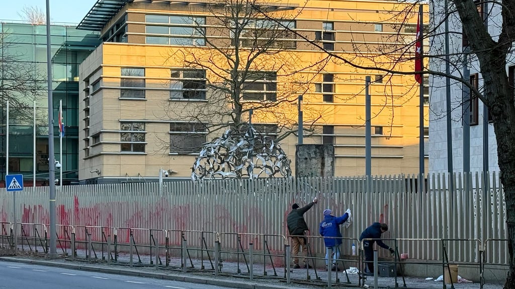 Die Gruppe zündete auch mehrere Rauchbomben vor dem Gebäude, Arbeiter reinigen den Zaun der Botschaft der Türkei nun.