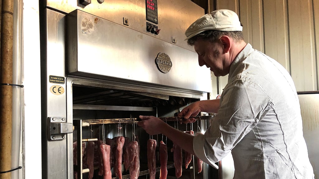 Fleischermeister Sven Matthes bestückt die Flüssigrauchanlage, die durch den Brand ebenfalls betroffen war, jetzt aber repariert ist.