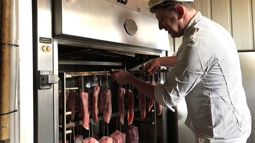 Fleischermeister Sven Matthes bestückt die Flüssigrauchanlage, die durch den Brand ebenfalls betroffen war, jetzt aber repariert ist.