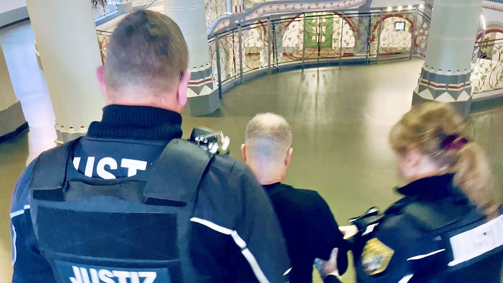 Justizbeamte führen den Hauptangeklagten Frank S., der in Bad Dürrenberg illegal mit Zigaretten gehandelt haben soll, aus dem Saal des Landgerichts Halle.