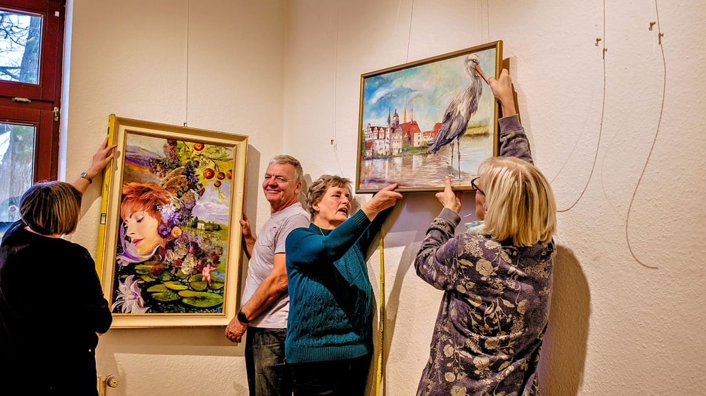 Jörg Hundt aus Dessau-Roßlau hängt mit den Frauen der Kreativ-WG die Ausstellungsbilder in der „SchkönArt-Galerie“.