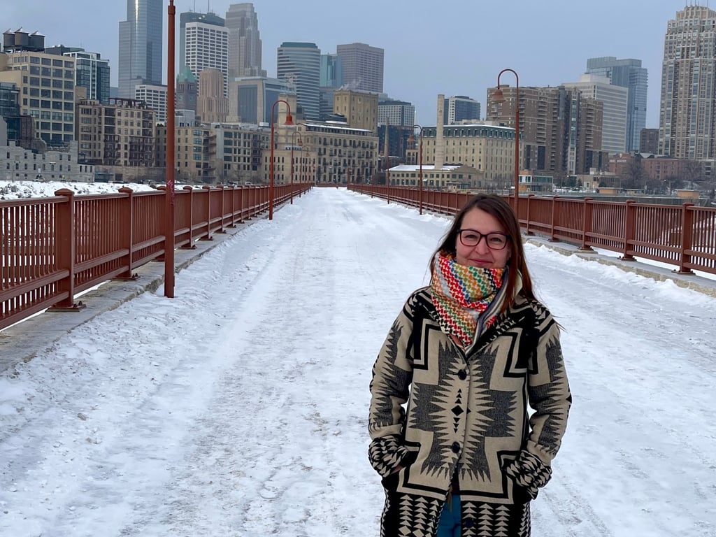 Juliane Schicker auf der Stone Arch Bridge vor ihrer Lieblingskulisse, wie sie sagt. Im Hintergrund die Downtown von Minneapolis. Seit Beginn des Einsatzes der Einwanderungspolizei ICE ist hier für Migranten vieles nicht mehr, wie es war.