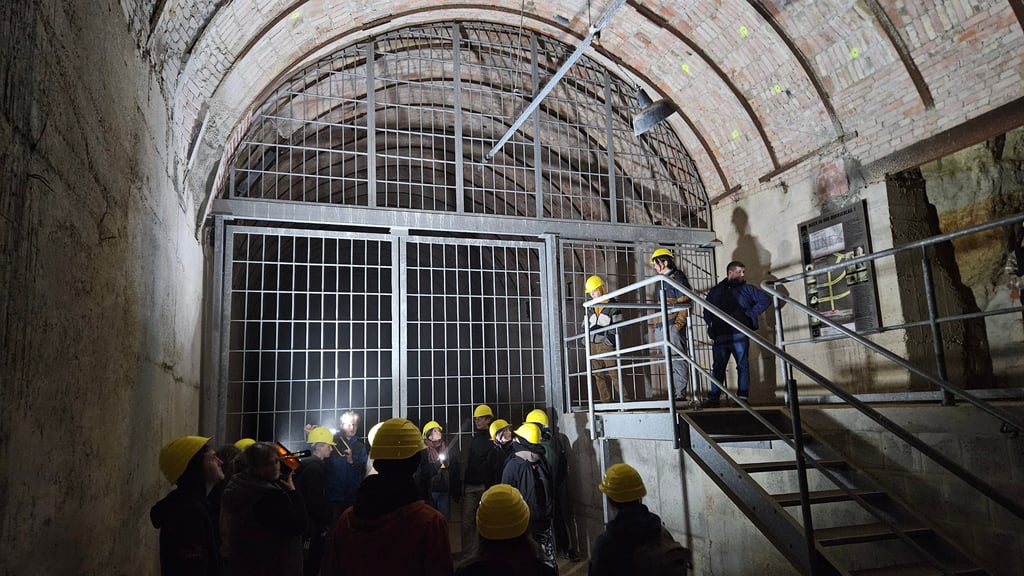 Eine Besuchergruppe besichtigt den kleinen zugänglichen Teil der reisigen unterirdischen, von Häftlingen des KZ Langenstein-Zwieberge in den Fels getriebenen Stollenanlage in den Thekenbergen bei Halberstadt.