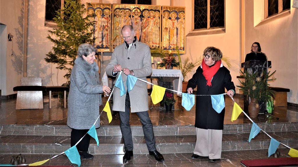 Mit der Verbindung zweier Wimpelketten als Symbol des Miteinanders eröffnete Bürgermeister Andreas Dittmann das Festjahr anlässlich des Jubiläums 130 Jahre katholische Kirche St. Jakobus.